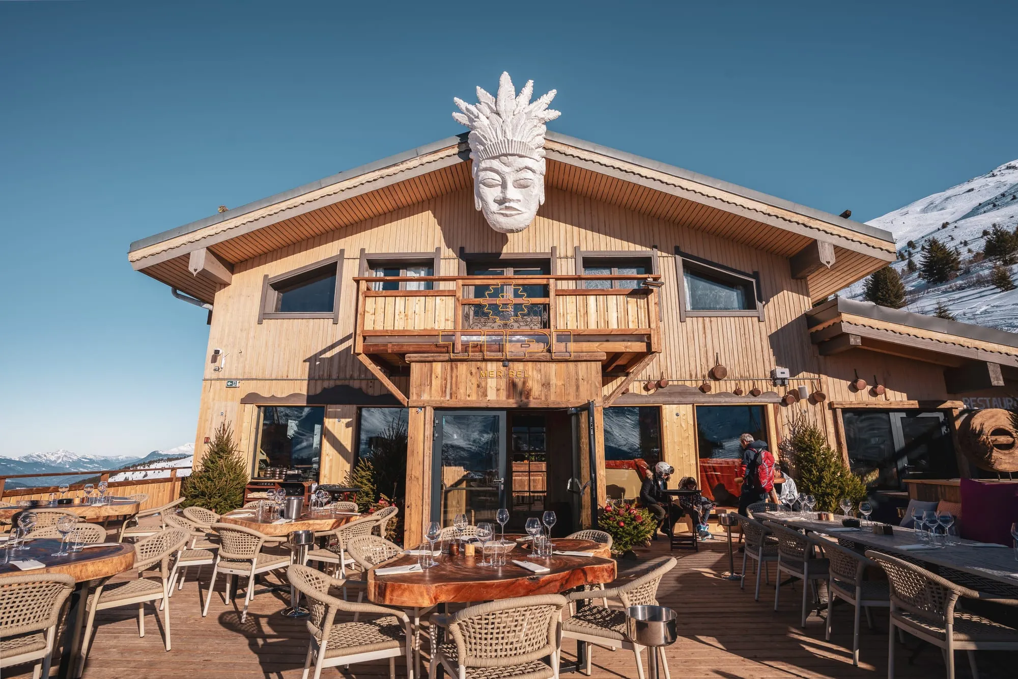 Le chalet de Tipi, son grand masque sculpté sur le toit, et la terrasse au pied des pistes.