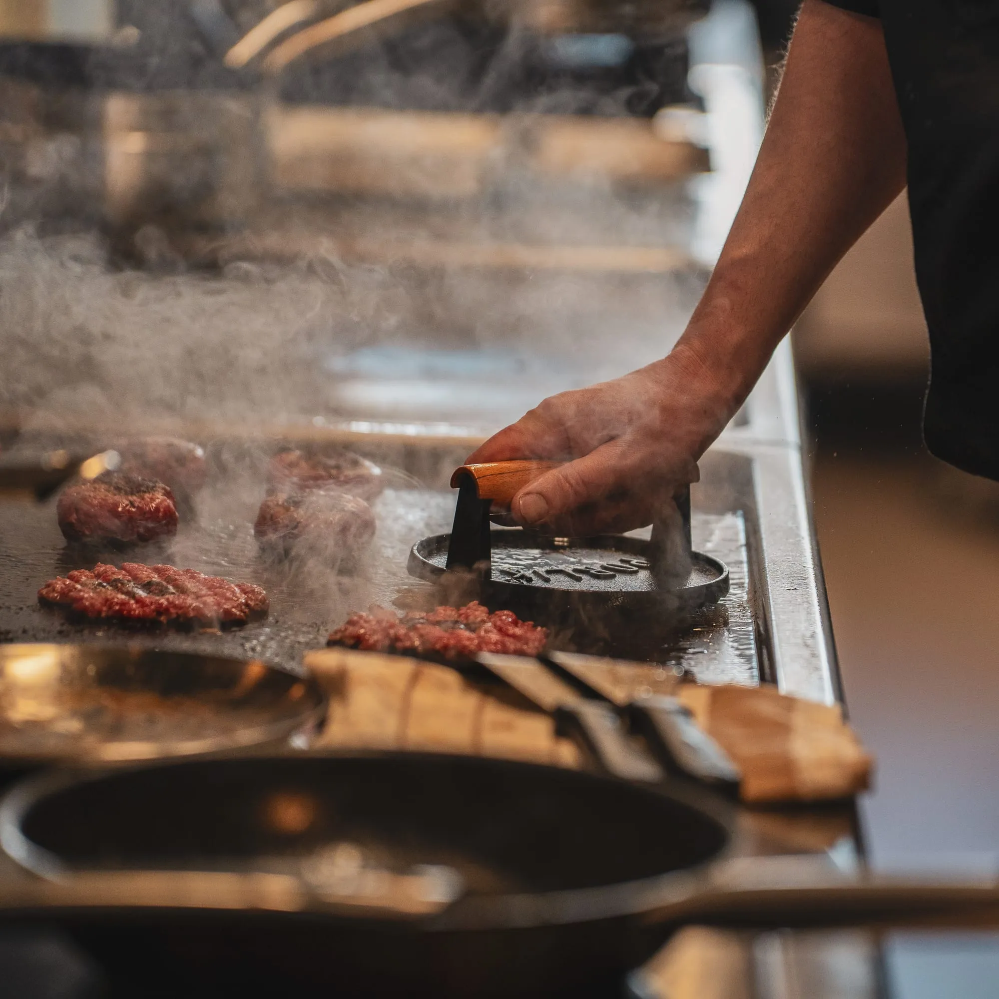 Des pièces de viande saisies sur la grille du feu de bois, en cuisine.